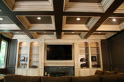 Antiqued Finished Entertainment Center with Floor To Ceiling Recess Panel Wainscot. Coffered Ceiling with Recess Lighting